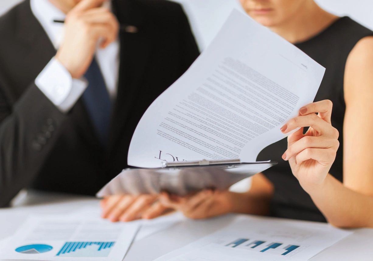 A group of people sitting at a table with papers.