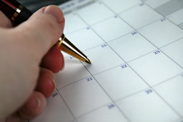 A person is writing on the calendar